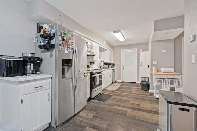 kitchen with dark hardwood / wood-style flooring, white cabinets, stainless steel appliances, and sink