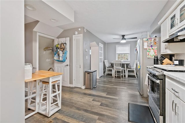 kitchen featuring white cabinetry, stainless steel stove, dark wood-type flooring, and ceiling fan