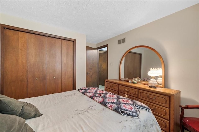 bedroom with a textured ceiling and a closet