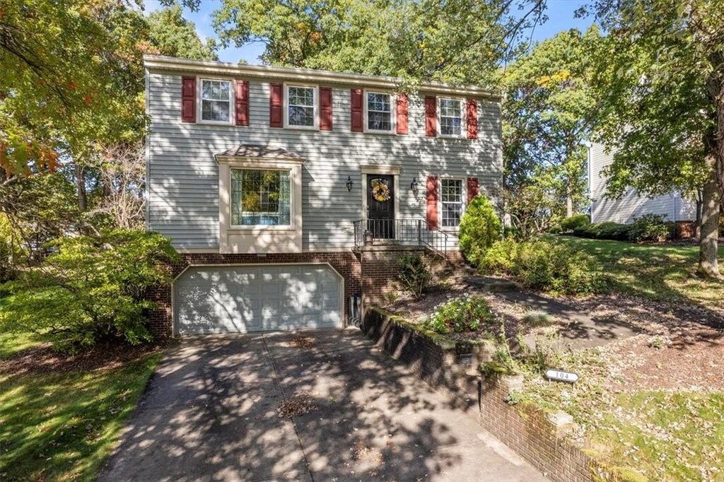 104 Parliament Dr, Moon/Crescent Twp, PA 15108 - colonial inspired home with driveway, a garage, and brick siding