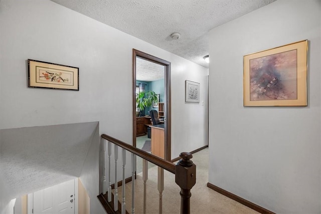 stairway with carpet and a textured ceiling