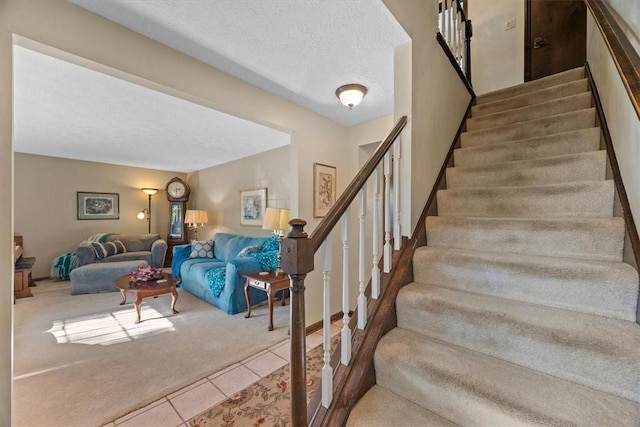 staircase featuring tile patterned flooring and a textured ceiling