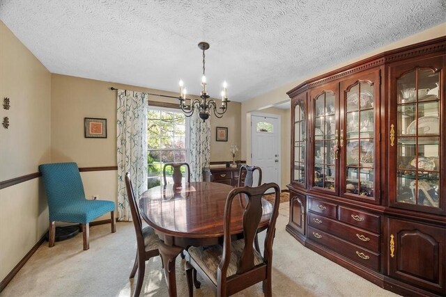 dining area with a notable chandelier, light colored carpet, and a textured ceiling