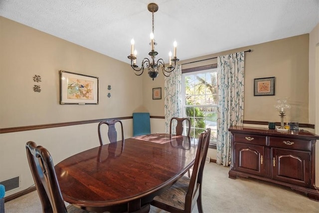 carpeted dining room with a textured ceiling and a notable chandelier