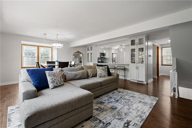 living room with dark hardwood / wood-style flooring and a chandelier