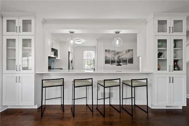 kitchen with white cabinets, sink, stainless steel appliances, and hanging light fixtures