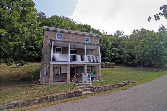 view of front of home featuring a balcony and a front yard