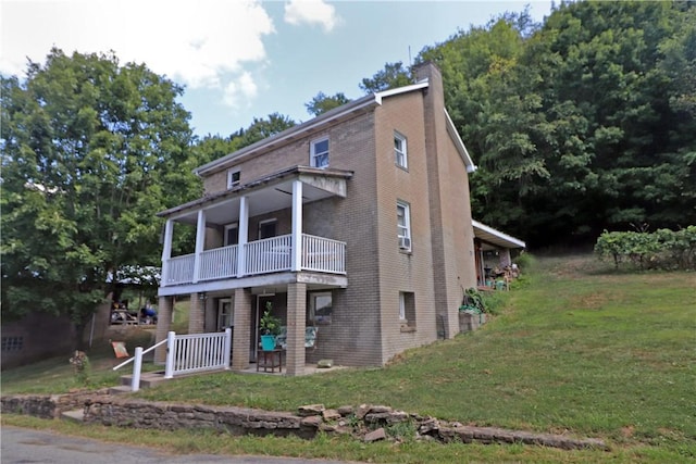 view of front facade featuring a balcony and a front yard