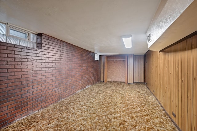 basement with light carpet, brick wall, and wood walls