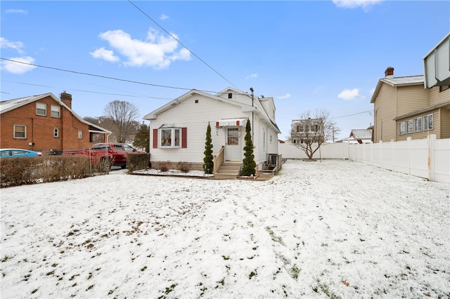 snow covered house with central AC unit