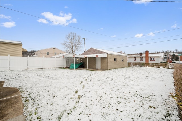 yard covered in snow with an outbuilding