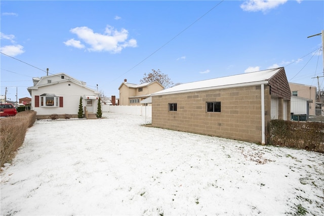 snow covered property with a garage