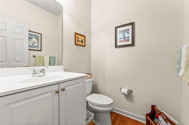 bathroom with hardwood / wood-style floors, vanity, and toilet