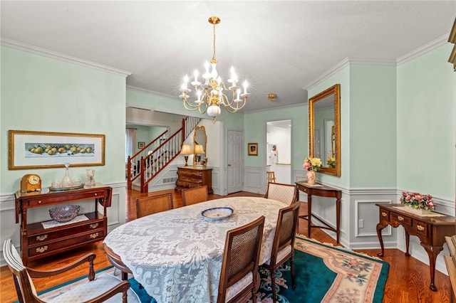 dining room featuring hardwood / wood-style flooring, crown molding, and an inviting chandelier