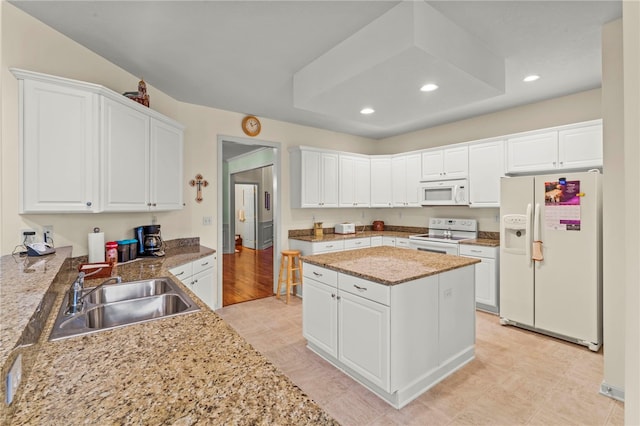 kitchen with light stone counters, sink, white cabinets, and white appliances