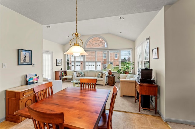 dining space with light tile patterned flooring and vaulted ceiling