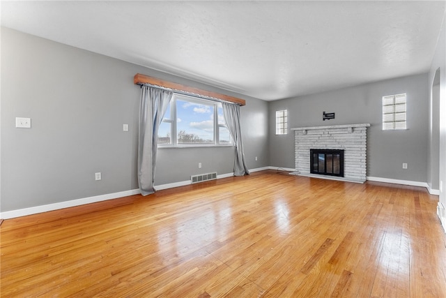 unfurnished living room featuring a fireplace and light wood-type flooring