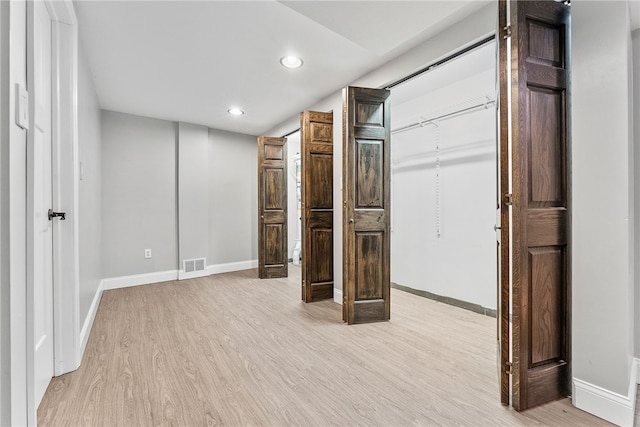 unfurnished bedroom with light wood-type flooring and a closet