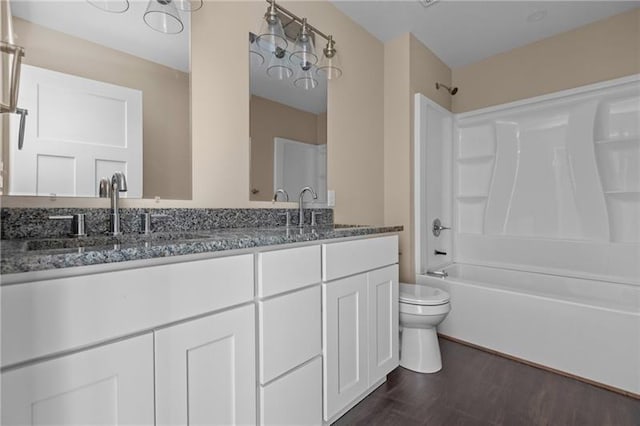 full bathroom with hardwood / wood-style floors, vanity, toilet, and tub / shower combination