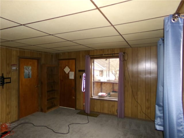 carpeted entrance foyer with wooden walls