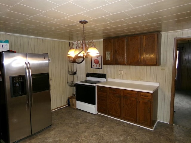 kitchen with stainless steel fridge, white electric range oven, pendant lighting, a chandelier, and wood walls