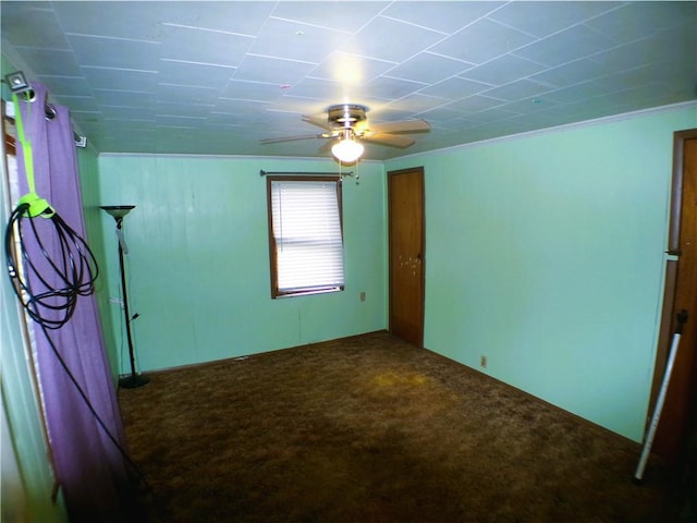 carpeted spare room featuring ceiling fan and crown molding