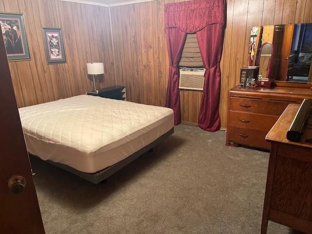 carpeted bedroom featuring wooden walls