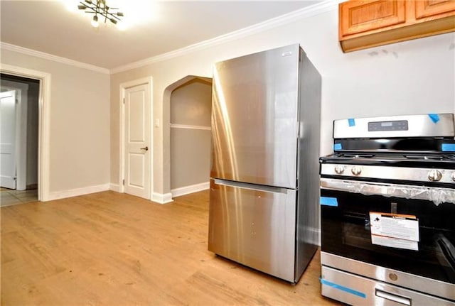 kitchen with light wood-type flooring, crown molding, and appliances with stainless steel finishes