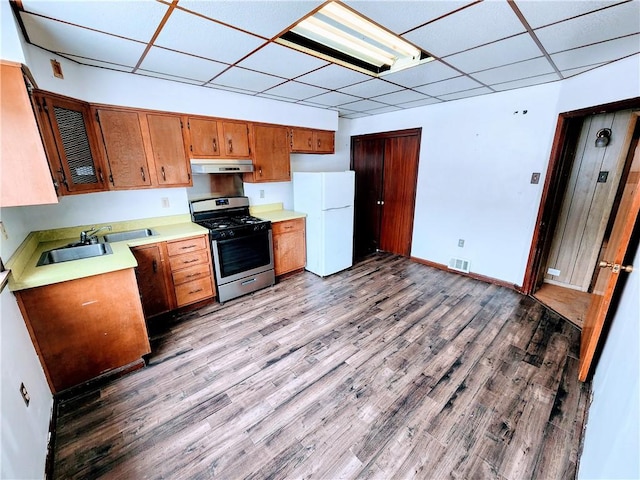 kitchen with a paneled ceiling, sink, light hardwood / wood-style floors, white fridge, and gas stove