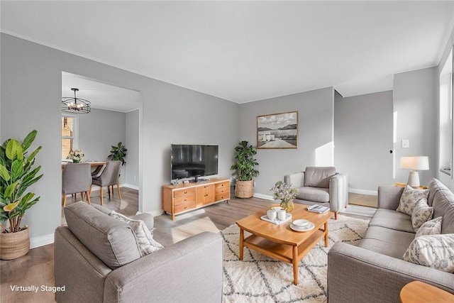 living room with light hardwood / wood-style flooring and a notable chandelier