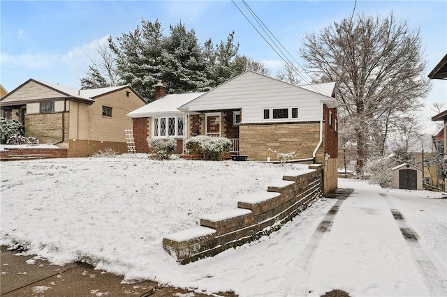 snow covered back of property with a storage shed