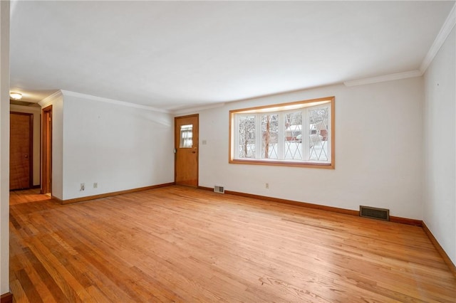 empty room with crown molding and light hardwood / wood-style floors