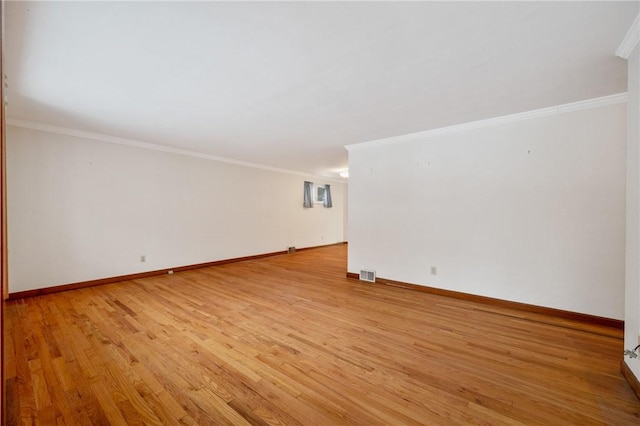 spare room featuring light hardwood / wood-style floors and ornamental molding