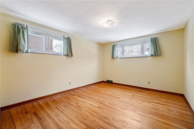 spare room featuring plenty of natural light and light hardwood / wood-style floors