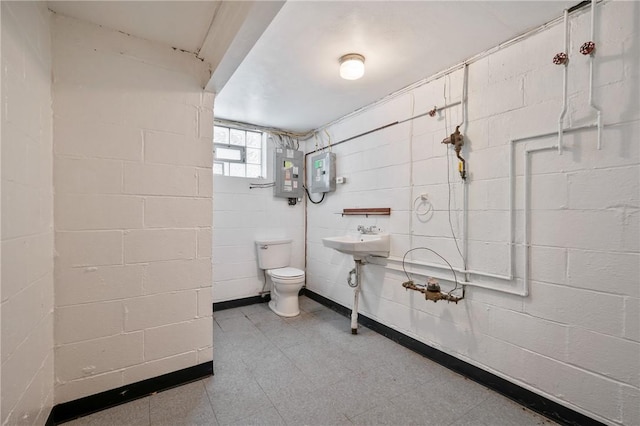 bathroom with toilet, sink, and electric panel