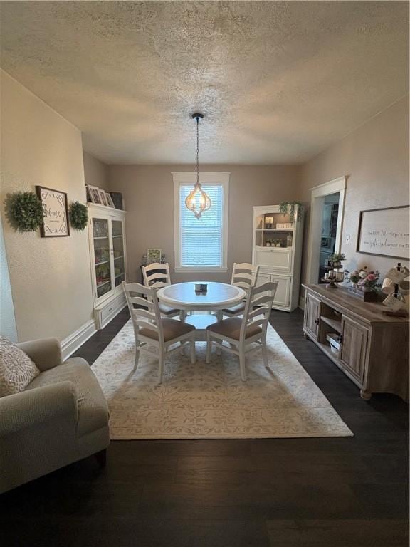 dining area with dark hardwood / wood-style flooring and a textured ceiling