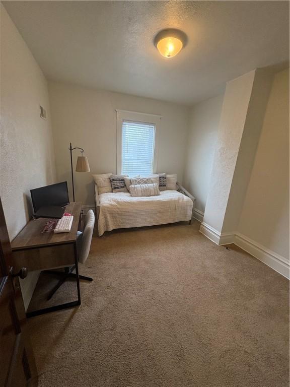 carpeted bedroom featuring a textured ceiling