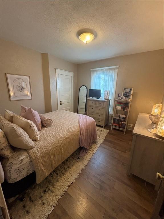 bedroom featuring dark wood-type flooring and a textured ceiling