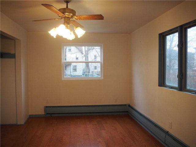 unfurnished bedroom featuring ceiling fan, wood-type flooring, and a baseboard heating unit