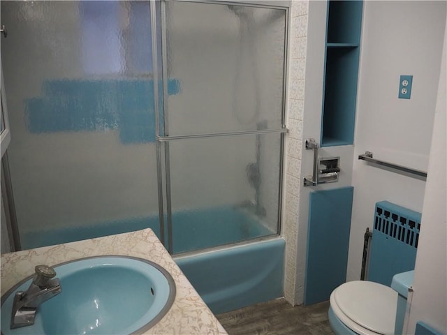 full bathroom with combined bath / shower with glass door, toilet, and sink