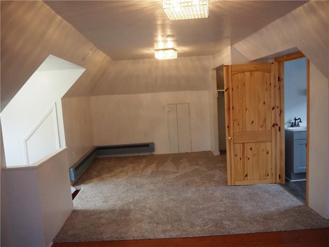 additional living space featuring carpet flooring, a baseboard radiator, lofted ceiling, and sink