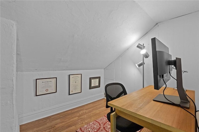 office with a textured ceiling, hardwood / wood-style floors, and vaulted ceiling