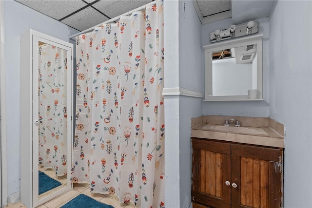 bathroom featuring vanity, a paneled ceiling, tile patterned floors, and curtained shower