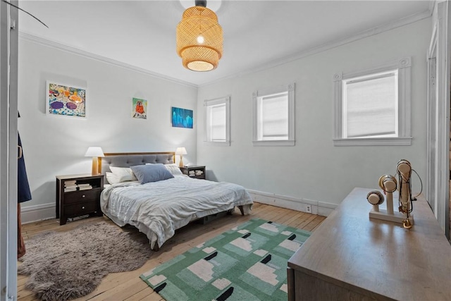 bedroom with hardwood / wood-style floors and ornamental molding