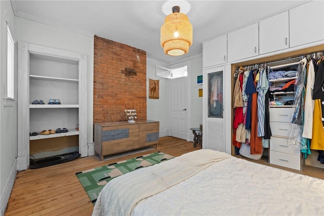 bedroom featuring light wood-type flooring, a closet, and ornamental molding