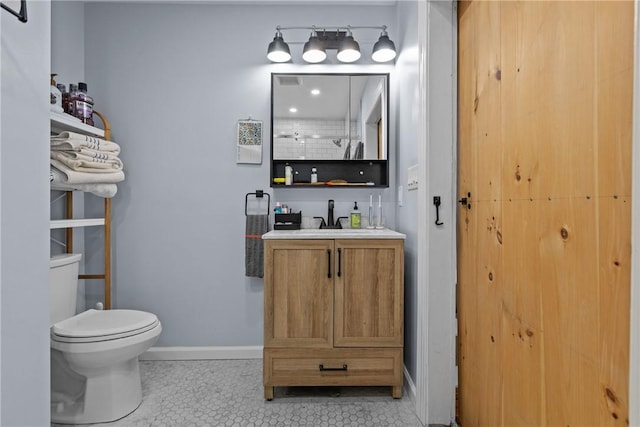 bathroom with toilet, vanity, and tile patterned floors