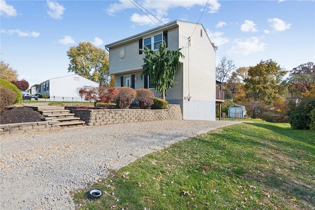 rear view of property with a lawn and a storage shed