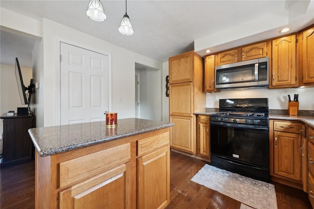 kitchen with pendant lighting, a center island, dark wood-type flooring, dark stone counters, and gas stove