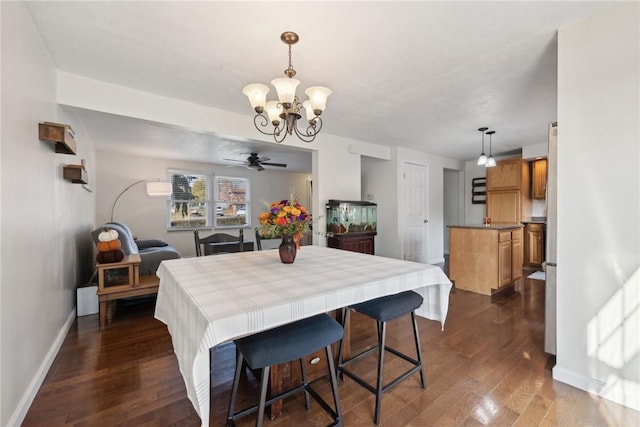 dining room featuring ceiling fan with notable chandelier and dark hardwood / wood-style floors