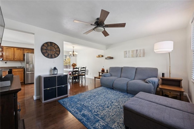 living room with ceiling fan with notable chandelier, dark hardwood / wood-style floors, and a wealth of natural light